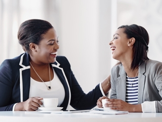 Two women connecting at work, over coffee.