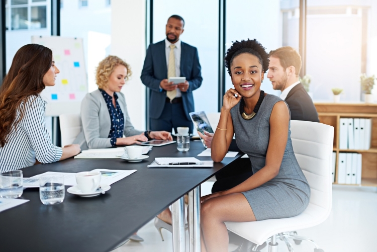 Employees sitting around while one looks at the camera